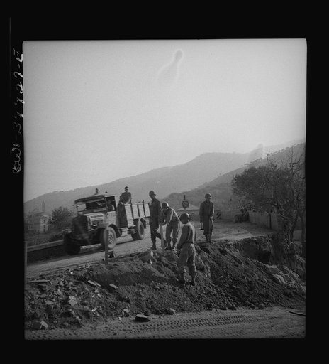 British equipment and troops repairing Sicilian roads demolished by the Germans