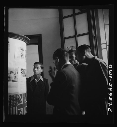 Catania, Sicily. Looking at photos and reading the news of life in Allied countries. This is of particular interest to Sicilians because it had been denied them during the Fascist years
