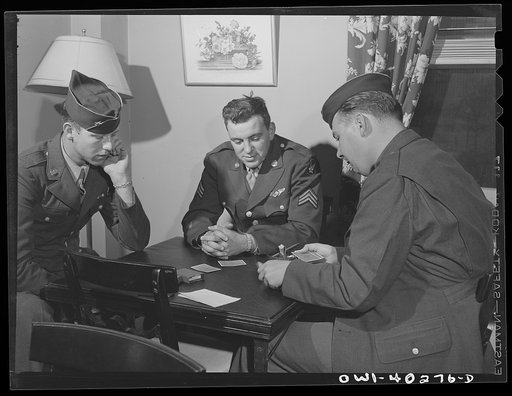 Washington, D.C. Soldiers waiting between trains playing cards in the game room at the United Nations service center
