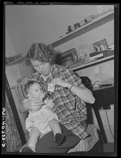 Washington, D.C. A child in the nursery at the United Nations service center trying to get the badge of the worker who is caring for her