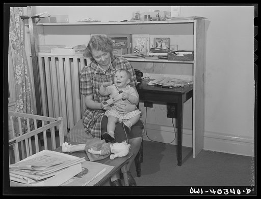 Untitled photo, possibly related to: Washington, D.C. A child in the nursery at the United Nations service center trying to get the badge of the worker who is caring for her