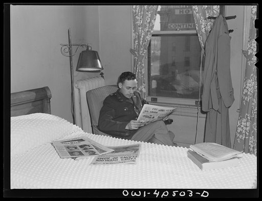 Washington, D.C. A lieutenant in the United States Army Air Transport Command reading the paper in his room at the United Nations service center