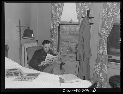 Washington, D.C. A lieutenant in the United States Army Air Transport Command reading the paper in his room at the United Nations service center