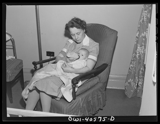 Washington, D.C. A volunteer worker feeding a baby at the nursery of the United Nations service center