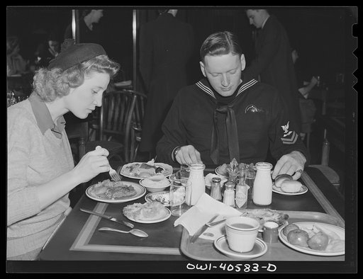 Washington, D.C. Hugh and Lynn Massman eating lunch at a cafeteria after a day of sightseeing. Their eight-weeks-old son is being taken care of at the United Nations service center nursery