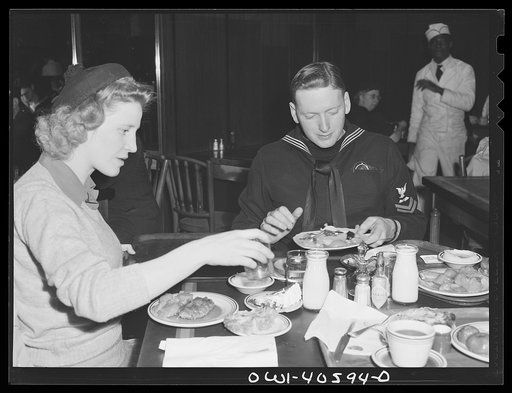 Washington, D.C. Hugh and Lynn Massman eating lunch at a cafeteria after a day of sightseeing. Their eight-weeks-old son is being taken care of at the United Nations Service Center nursery