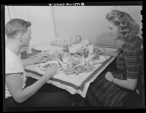 Washington, D.C. Hugh Massman, a second class petty officer who is studying in Washington, and his wife eating dinner. Joey, their son, sleeps on a pad on the table