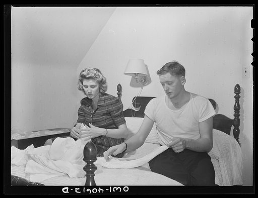 Washington, D.C. In the evening, Hugh Massman and his wife fold diapers. Joey's bureau drawer crib is moved to the side of their bed for the night
