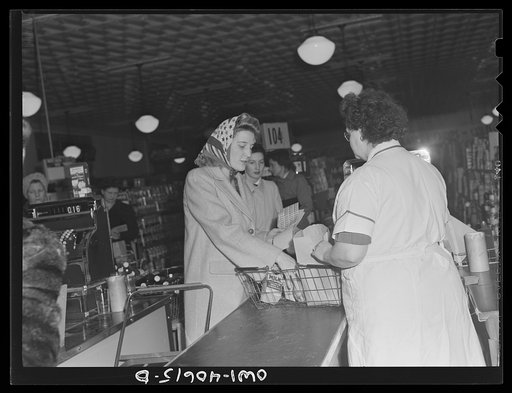 Washington, D.C. Lynn Massman, wife of a second class petty officer who is studying in Washington, shopping for groceries. While Lynn shops, her landlady keeps an eye on baby Joey