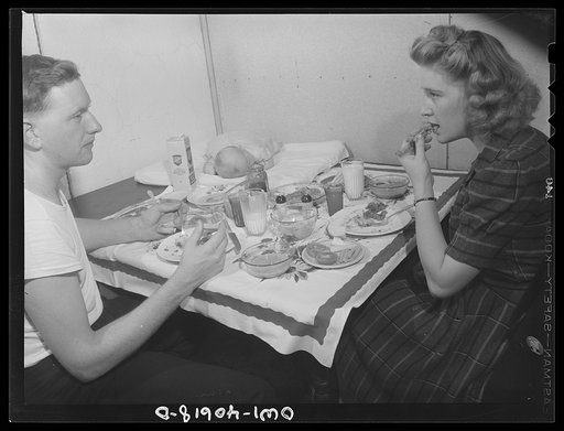 Washington, D.C. Hugh Massman,  a second class petty officer who is studying in Washington, and his wife eating dinner. Joey, their son, sleeps on a pad on the table