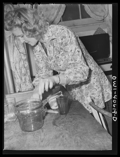 Washington, D.C. Lynn Massman, wife of a second class petty officer who is studying in Washington, does the breakfast dishes after feeding baby Joey