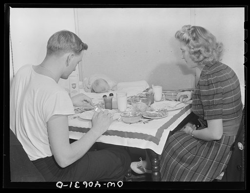 Washington, D.C. Hugh Massman, a second class petty officer who is studying in Washington, and his wife eating dinner. Joey, their son, sleeps on a pad on the table