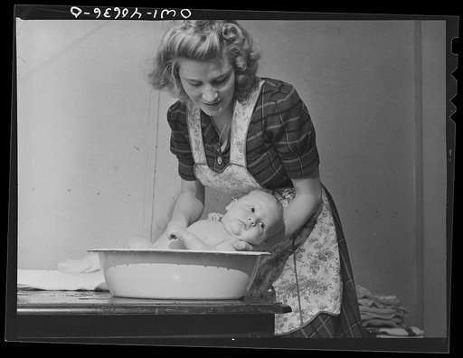 Washington, D.C. Lynn Massman, wife of a second class petty officer studying in Washington, D.C. giving eight weeks old Joey his daily bath