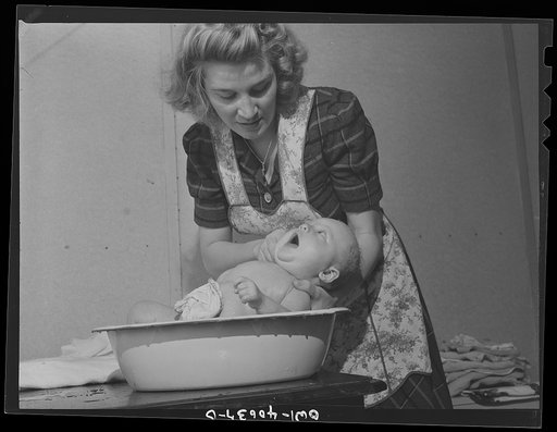 Washington, D.C. Lynn Massman, wife of a second class petty officer studying in Washington, D.C. giving eight weeks old Joey his daily bath