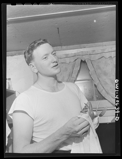 Washington, D.C. After dinner, Hugh Massman, a second class petty officer studying in Washington, does the dishes while Lynn feeds the baby