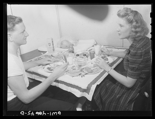 Untitled photo, possibly related to: Washington, D.C. Hugh Massman, a second class petty officer who is studying in Washington, D.C. and his wife eating dinner. Joey, their son, sleeps on a pad on the table