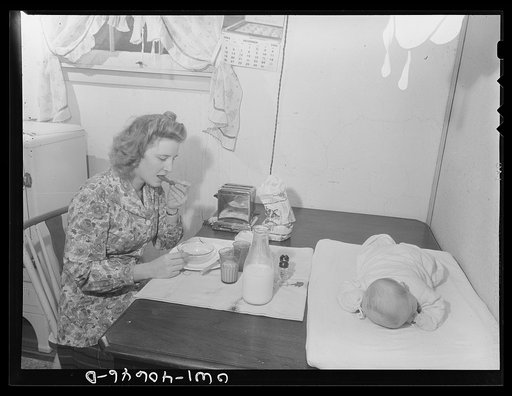 Washington, D.C. Lynn Massman, wife of a student at the Naval Air Station, eating breakfast while her eight-weeks-old son takes a nap