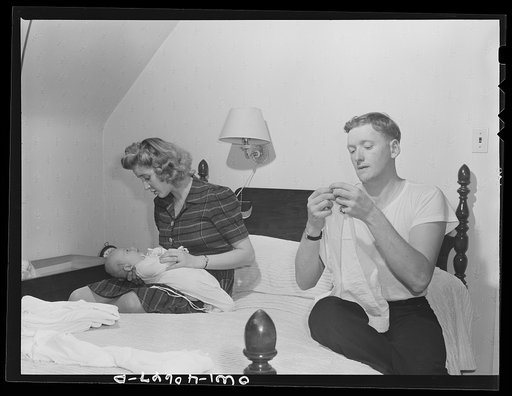 Washington, D.C. In the evening, Hugh Massman and his wife fold diapers. Joey's bureau drawer crib is moved to the side of their bed for the night