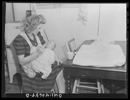 Washington, D.C. Lynn Massman, wife of a second class petty officer studying in Washington, D.C., feeding her son Joey cereal in the morning