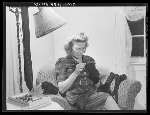 Washington, D.C. Lynn Massman, wife of a second class petty officer studying in Washington, D.C., darns socks in the afternoon while baby Joey has his nap