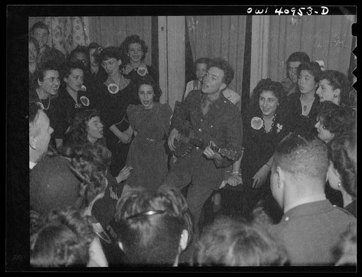 Washington, D.C. Pete Seeger, noted folk singer, leading the crowd in "When We March into Berlin" at the opening of the Washington labor canteen, sponsored by the United Federal Workers of American, Congress of Industrial Organizations (CIO)