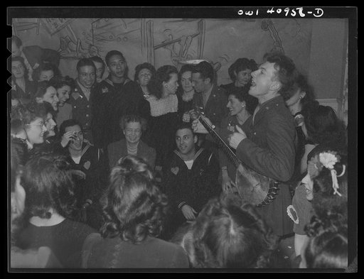 Washington, D.C. Pete Seeger, noted folk singer entertaining at the opening of the Washington labor canteen, sponsored by the United Federal Labor Canteen, sponsored by the Federal Workers of American, Congress of Industrial Organizations (CIO)