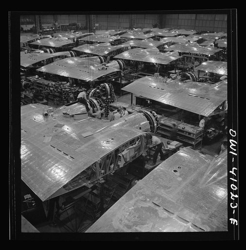 Untitled photo, possibly related to: Boeing aircraft plant, Seattle, Washington. Production of B-17F (Flying Fortress) bombing planes. Wing section, each containing two Wright engines, await mating with fuselage section of the B-17F (Flying Fortress) bomber