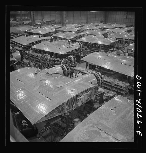 Untitled photo, possibly related to: Boeing aircraft plant, Seattle, Washington. Production of B-17F (Flying Fortress) bombing planes. Wing section, each containing two Wright engines, await mating with fuselage section of the B-17F (Flying Fortress) bomber