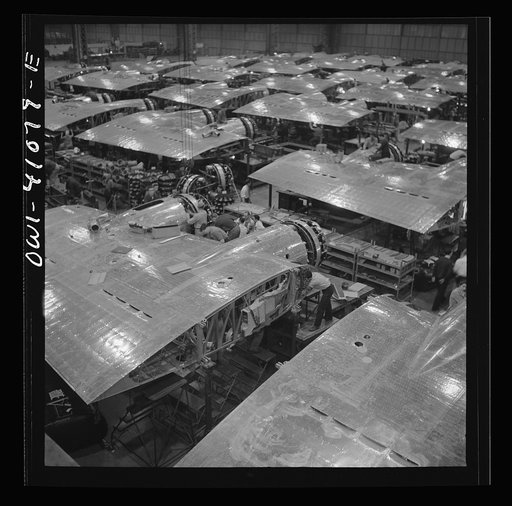 Untitled photo, possibly related to: Boeing aircraft plant, Seattle, Washington. Production of B-17F (Flying Fortress) bombing planes. Wing section, each containing two Wright engines, await mating with fuselage section of the B-17F (Flying Fortress) bomber