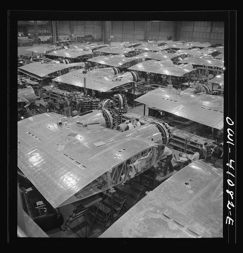 Untitled photo, possibly related to: Boeing aircraft plant, Seattle, Washington. Production of B-17F (Flying Fortress) bombing planes. Wing section, each containing two Wright engines, await mating with fuselage section of the B-17F (Flying Fortress) bomber
