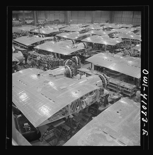 Boeing aircraft plant, Seattle, Washington. Production of B-17F (Flying Fortress) bombing planes. Wing section, each containing two Wright engines, await mating with fuselage section of the B-17F (Flying Fortress) bomber