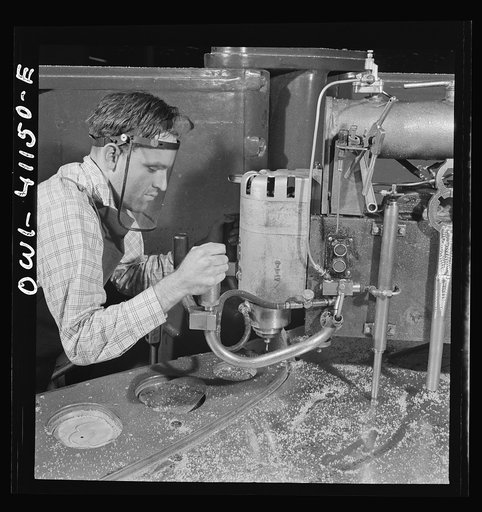 Untitled photo, possibly related to: Boeing aircraft plant, Seattle, Washington. Production of B-17F (Flying Fortress) bombing planes. Worker operating a routing machine which uses metal template as a guide to make wood patterns. In the early stage of development wood supplements metal in the constr