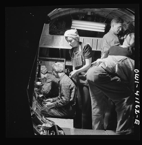 Boeing aircraft plant, Seattle, Washington. Production of B-7 F (Flying Fortress) bombing planes. A team of workers completing assembly and fitting operations on the interior of a fuselage section