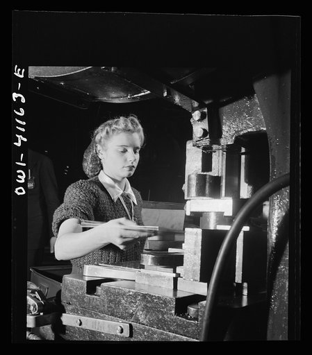 Boeing aircraft plant, Seattle, Washington. Production of B-17F (Flying Fortress) bombing planes. Girl working on a machine
