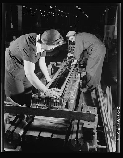 Boeing aircraft plant, Seattle, Washington. Production of B-17 (Flying Fortress) bombing planes. Two women working on a machine