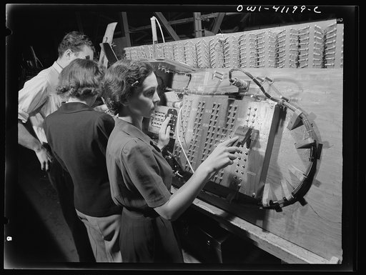 Untitled photo, possibly related to: Boeing aircraft plant, Seattle, Washington. Production of B-17 (Flying Fortress) bombing planes. Girl checking electrical wiring assemblies