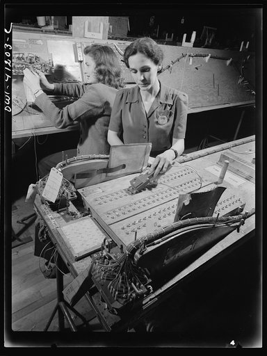 Untitled photo, possibly related to: Boeing aircraft plant, Seattle, Washington. Production of B-17 (Flying Fortress) bombing planes. Girl checking electrical wiring assemblies