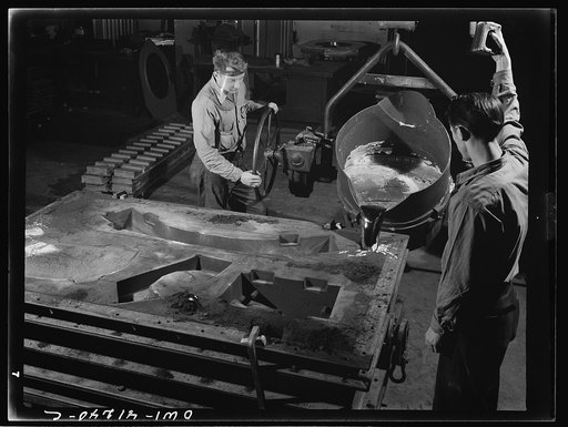 Boeing aircraft plant, Seattle, Washington. Production of B-17 (Flying Fortress) bombing planes. Pouring a lead die to be used in the production of parts for B-17 (Flying Fortress) bombers