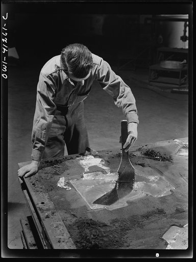 Boeing aircraft plant, Seattle, Washington. Production of B-17 (Flying Fortress) bombing planes. Man working on a mold (?) for a part of the plane