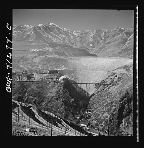 Bingham Canyon, Utah. Overall view of an open-pit mine of the Utah Copper Company showing railroads, buildings, trestle bridge, and mountains of ore