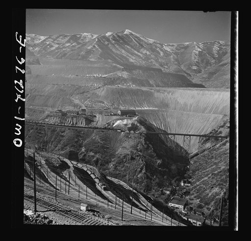 Untitled photo, possibly related to: Bingham Canyon, Utah. Overall view of an open-pit mine of the Utah Copper Company showing railroads, buildings, trestle bridge, and mountains of ore