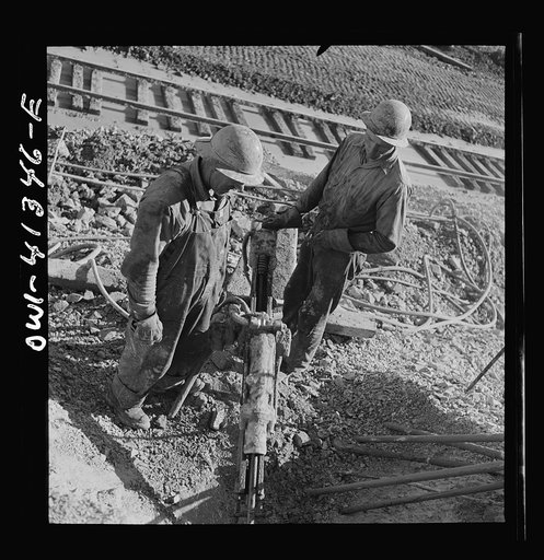 Untitled photo, possibly related to: Bingham Canyon, Utah. Drilling blast holes with a rock-drill machine in an open-pit mine operated by the Utah Copper Company