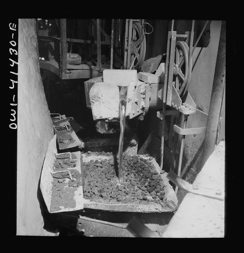 Phelps Dodge refining company, El Paso, Texas. Molten copper  being poured from the refinng furnace. It is run through a bed of coke to prevent oxidation before the copper is cast into molds