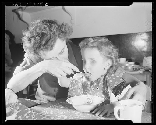 New York, New York. Mrs. Speer, director of the nursery, is teaching two-year-old Pauline Nodhturft how to feed herself at the Lighthouse, an institution for the blind, at 111 East Fifty-ninth Street