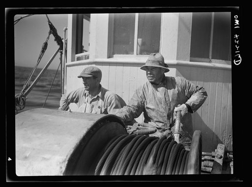 On board a fishing vessel out from Gloucester, Massachusetts. Winch control men intent on seeing to it that the proper amount of cable is let out at the proper spot