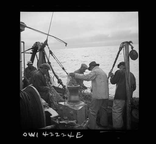 Gloucester, Massachusetts. At sunset fishermen mend nets torn by rocks on the ocean floor. A shortage of linen twine and manila hemp needed for nets is only one of the war-time difficulties fishermen today must face