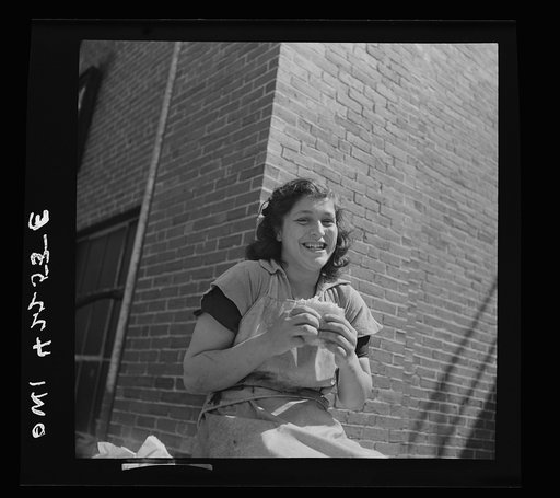 On board a fishing vessel out from Gloucester, Massachusetts. A girl who works in the fish packing industry eating her lunch