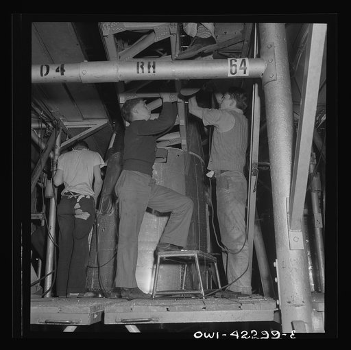 Seattle, Washington. Boeing aircraft plant. Production of B-17F (Flying Fortress) bombing planes. Riveters working on the fuselage section