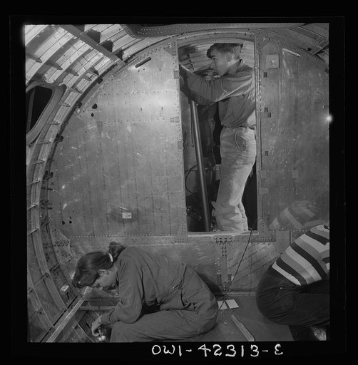 Boeing aircraft plant, Seattle, Washington. Production of B-17F (Flying Fortress) bombing planes. A crew working in a nearly completed fuselage section