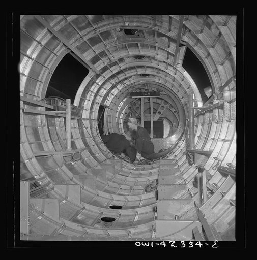 Untitled photo, possibly related to: Boeing aircraft plant, Seattle, Washington. Production of B-17F (Flying Fortress) bombing planes. A crew working in a nearly completed fuselage section